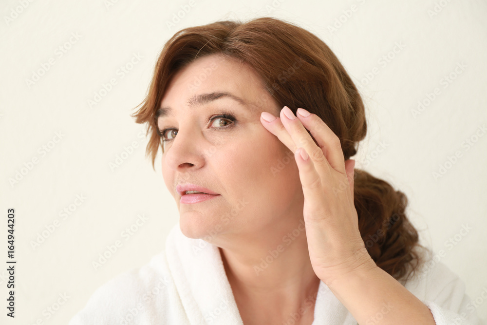 Beautiful elderly woman posing on light background Beautiful elderly woman posing on light background