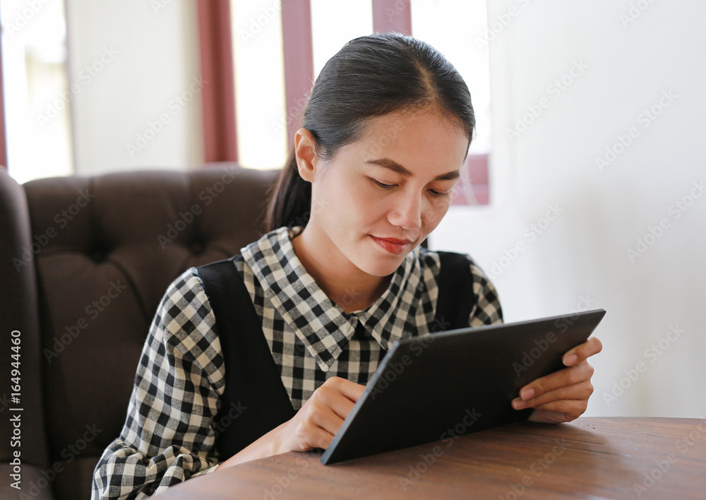 Young asian woman using tablet in the library. Young asian woman using tablet in the library.