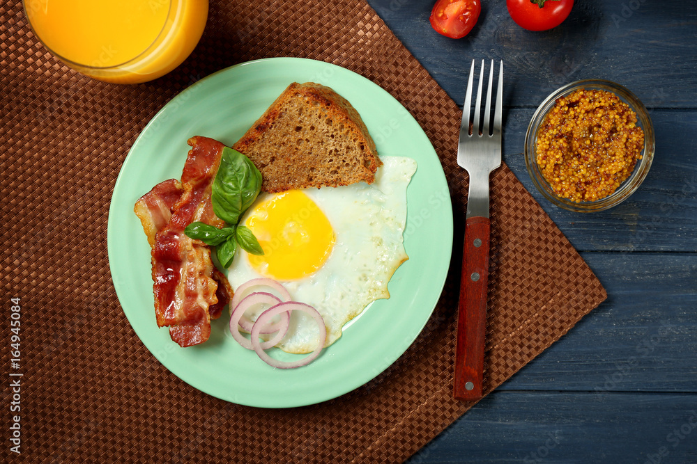 Delicious over easy egg with toast and bacon on kitchen table Delicious over easy egg with toast and bacon on kitchen table