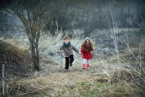Fotografie ittle boy and girl stand in a field in early spring