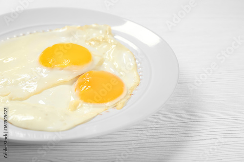 Delicious breakfast with over easy eggs on wooden background