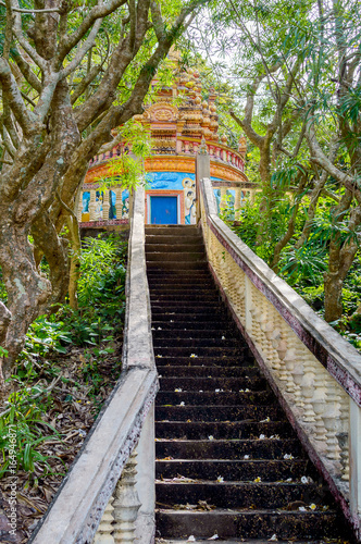 Stairway going up to the buddhist temple in jungle forest photo