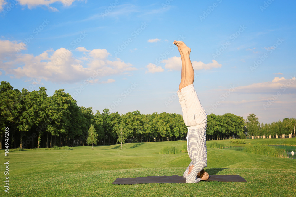 Young man practicing yoga outdoors