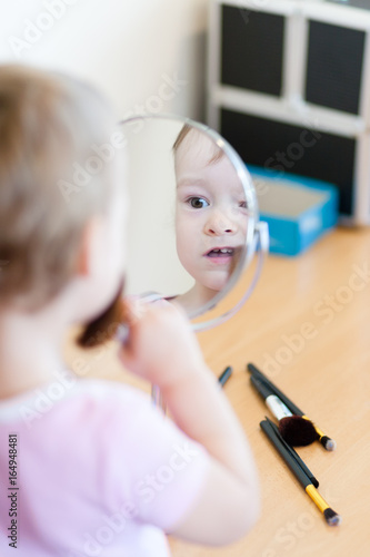 2 years old girl child is doing makeup
