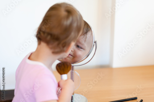 2 years old girl child is doing makeup