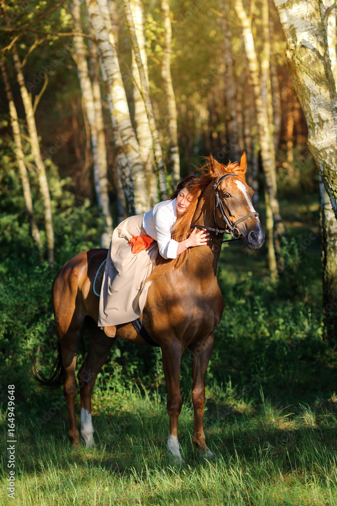 woman rides a horse in the beautiful evening park woman rides a horse in the beautiful evening park