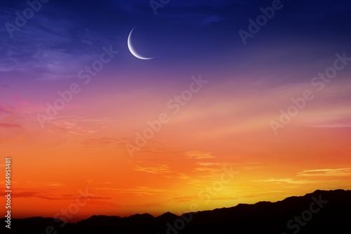 Ramadan background . Red sunset and moon . Mubarak background . Against the background of clouds . beautiful sky .