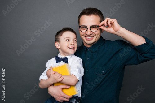 Father in glasses embracing son posing