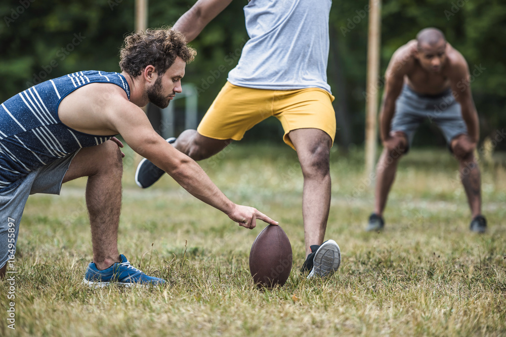 group of young multicultural men playing football on court group of young multicultural men playing football on court