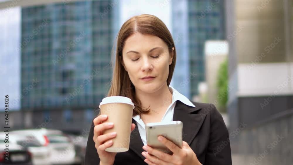 Businesswoman using smart phone in city downtown, professional female browsing chatting reading news Businesswoman using smart phone in city downtown, professional female browsing chatting reading news