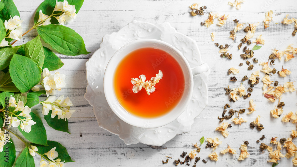 Cup of tea with jasmine flowers on a white table Cup of tea with jasmine flowers on a white table