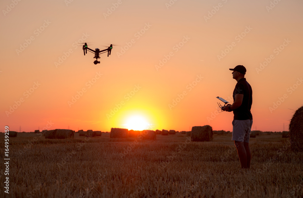 Man operating a professional drone at sunset Man operating a professional drone at sunset