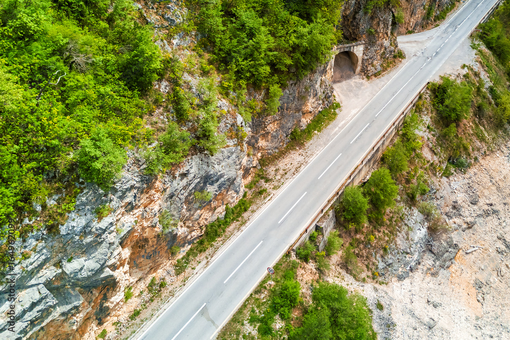 Top view of an empty asphalt road and a tunnel in the mountains