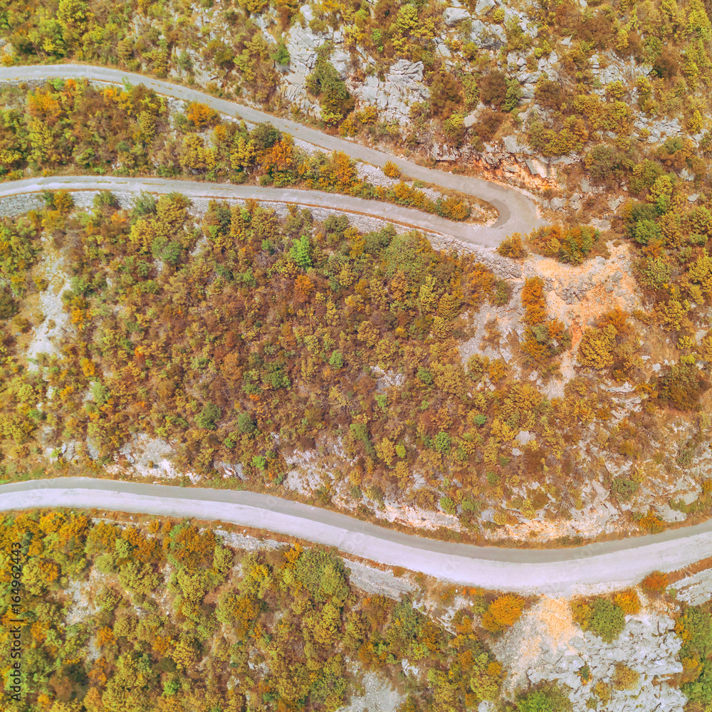 Top view of a winding highway in the autumn mountains