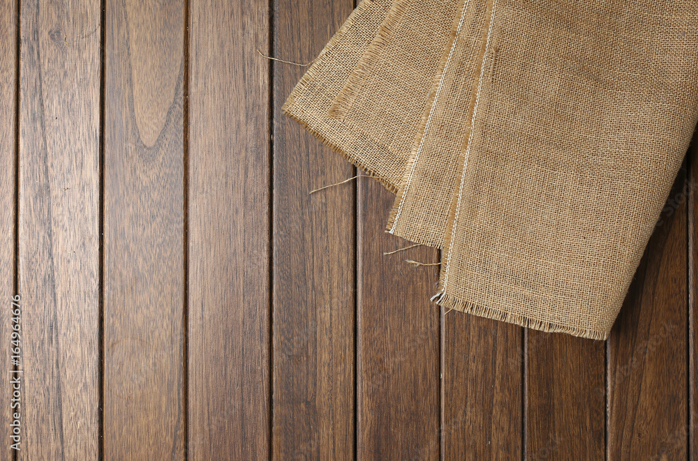 hessian cloth on wooden table - obrazy, fototapety, plakaty 