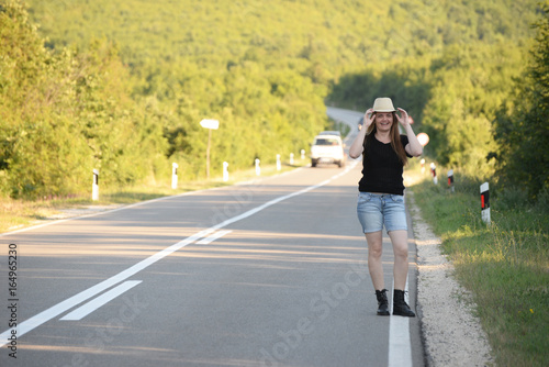 Woman Walking on the road in mountains at sunset. Forty Years old woman on the road © Ivan