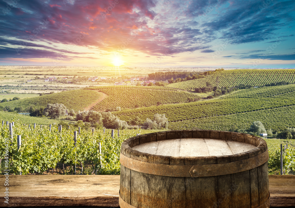 Red wine with barrel on vineyard in green Tuscany, Italy