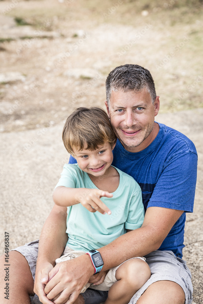 Father and son cuddling on the beach Father and son cuddling on the beach
