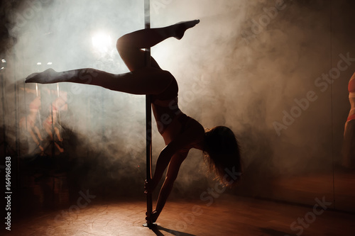 Fotografía young hot woman in sexy lingerie performs sensual pole dance
