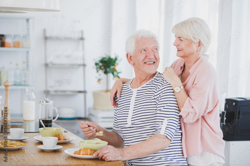 Man eating breakfast with woman behind him Man eating breakfast with woman behind him