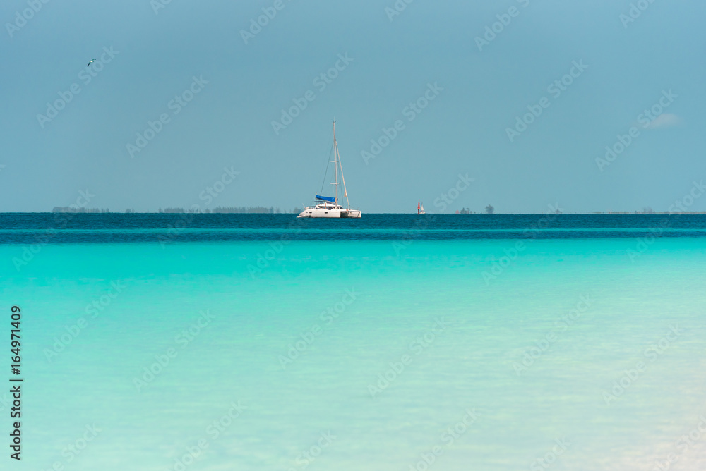 Yacht at the beach Playa Paradise of the island of Cayo Largo, Cuba. Copy space for text. Yacht at the beach Playa Paradise of the island of Cayo Largo, Cuba. Copy space for text.