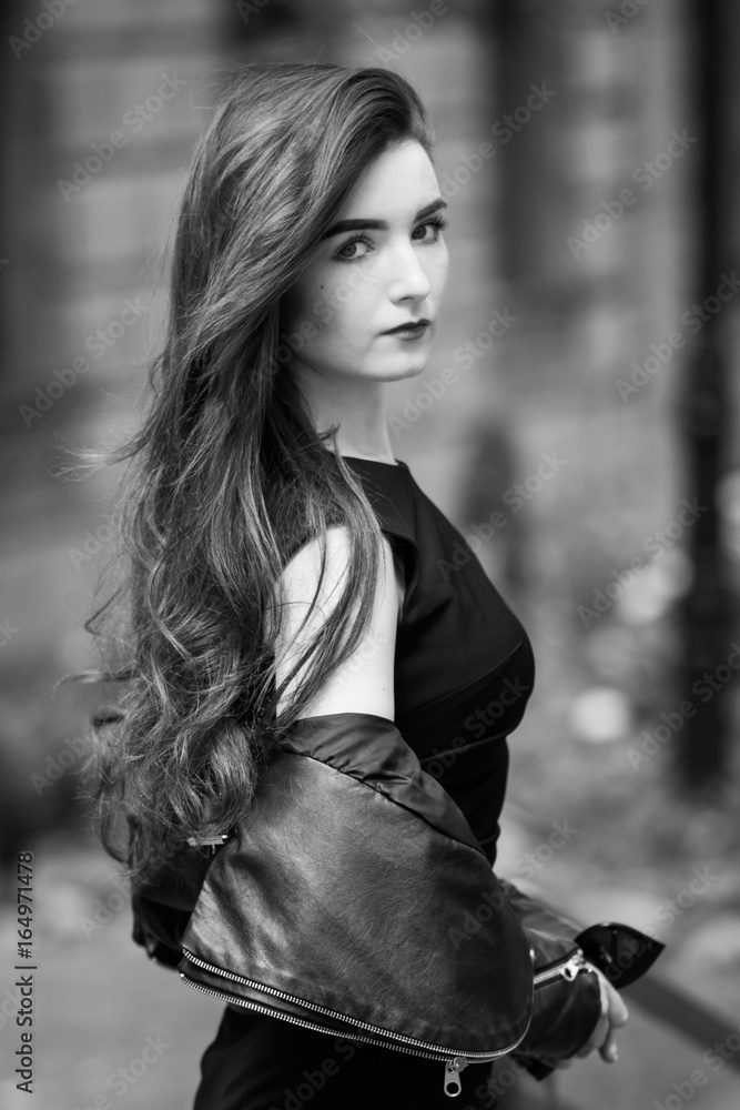 portrait of elegant woman in black dress walking in city portrait of elegant woman in black dress walking in city