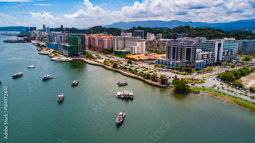 Kota Kinabalu city aerial view above sea level with boats berthing on the sea photo
