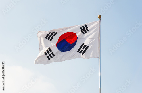 South Korea flag waving with blue sky in background.