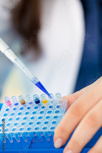 Young female technician in genetic laboratory with PCR