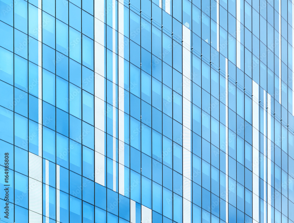 Glass facade of modern building. Cloudy sky reflects in glass