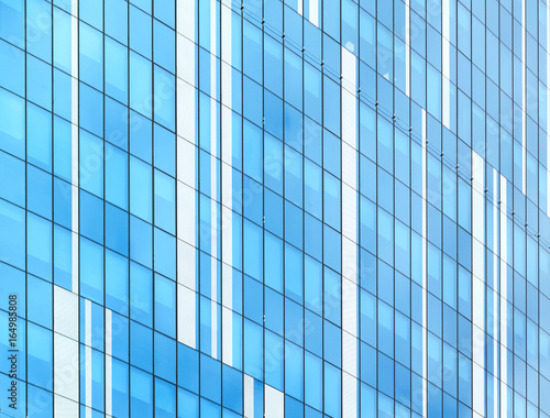 Glass facade of modern building. Cloudy sky reflects in glass