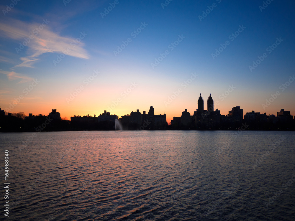 Central Park Reservoir and NYC skyline, as the sun sets.