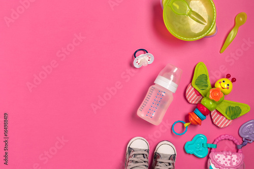 Baby toys and accessories on pink background. Top view