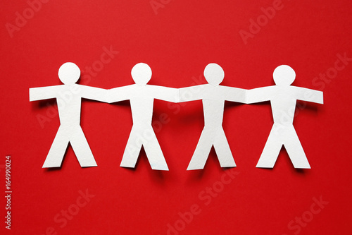 Quadro su tela chain of paper people on red background