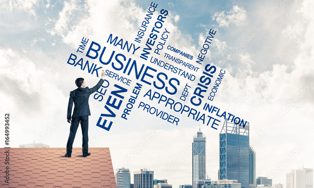 Young businessman standing on house roof and writing leadership Young businessman standing on house roof and writing leadership