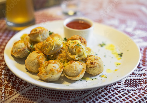 Traditional Russian pelmeni with cheese and tomato sauce.