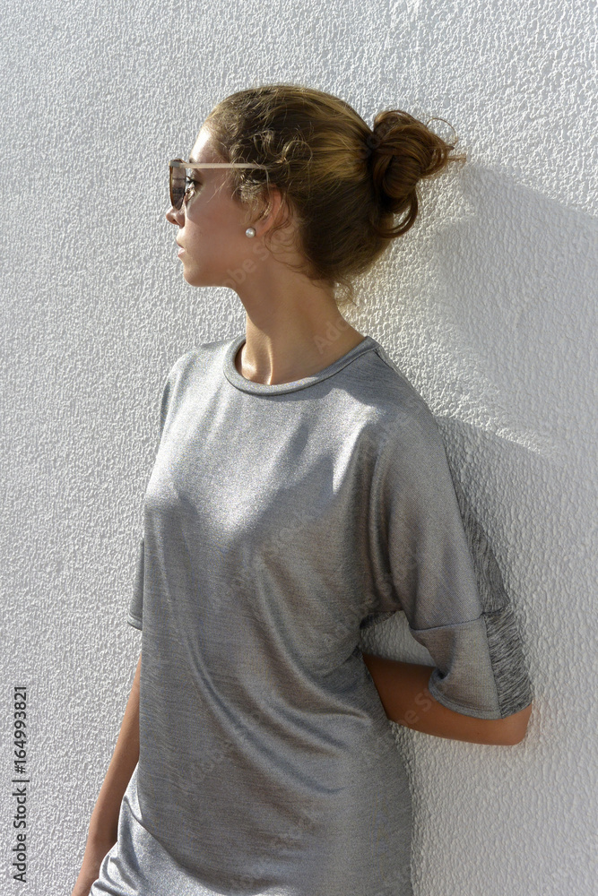 La chica joven y guapa vestida en vestido gris y lleva las gafas del sol  esta en la terraza foto de Stock | Adobe Stock