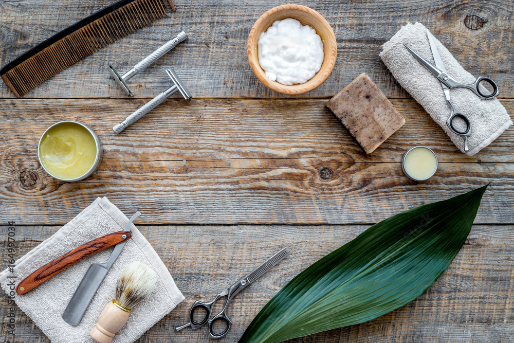 Barber workplace. Shaving brush, razor, foam, sciccors on wooden table background top view copyspace Barber workplace. Shaving brush, razor, foam, sciccors on wooden table background top view copyspace