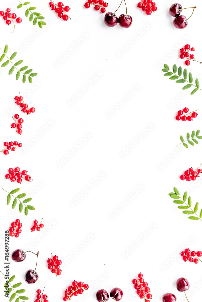 Berry frame. Red currant, cherry and leaves on white background top view copyspace Berry frame. Red currant, cherry and leaves on white background top view copyspace