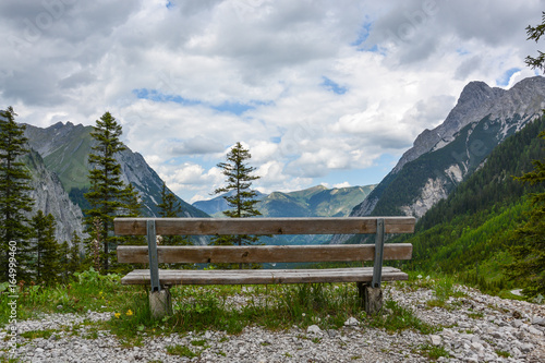 A wooden bench to rest on a hill in the mountains of the Karwendelgebirge