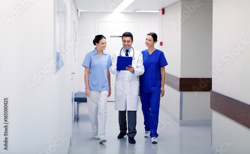 group of smiling medics at hospital with clipboard