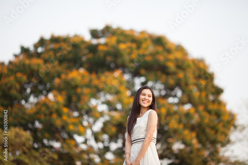Pretty Thai girl at the park with tree blurred background