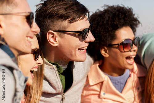 happy teenage friends in shades laughing outdoors