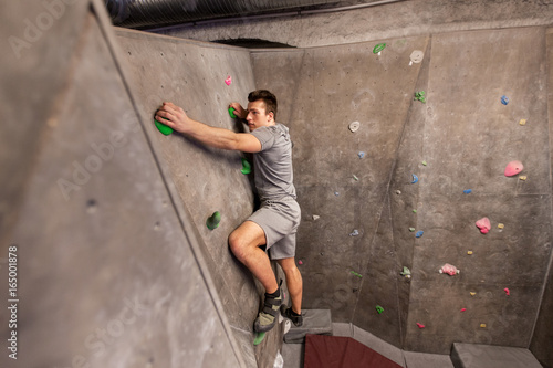 young man exercising at indoor climbing gym