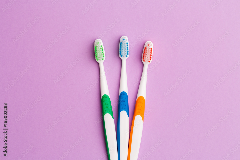 Photo of three multi-colored toothbrushes Photo of three multi-colored toothbrushes