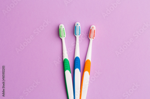 Photo of three multi-colored toothbrushes