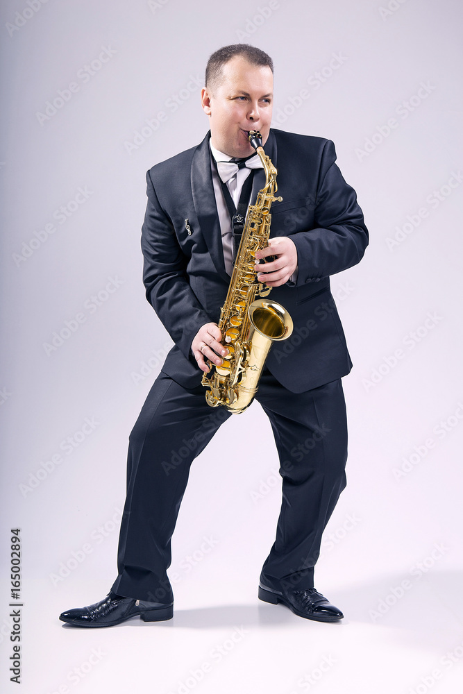 Fototapeta premium Melody saxophone. Man. European. He plays the saxophone. Dressed in a suit.