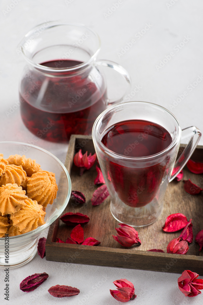 The cup with double glass with hibiscus tea is on a table. The cup with double glass with hibiscus tea is on a table.