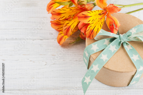 Arrangement of orange lily flowers and gift box