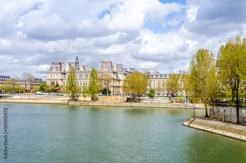 Paris City Hall (Hotel de Ville) with the Seine river and a part of the Ille on the foreground on a sunny spring day in thisbeautiful French and European capital